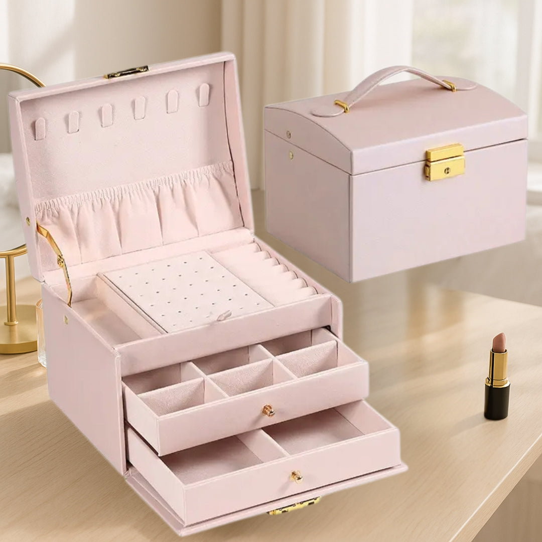 Boite à bijoux rose féminine et raffinée, ouverte sur une coiffeuse avec colliers, bagues et boucles d’oreilles parfaitement rangés dans les compartiments doux.