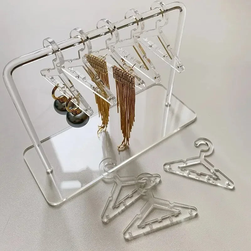 Rangement pour bijoux cristallin en acrylique transparent avec mini cintres, idéal pour organiser boucles d’oreilles et colliers avec élégance.