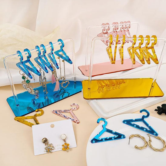 Rangement pour bijoux en acrylique transparent au design minimaliste sur une coiffeuse moderne.