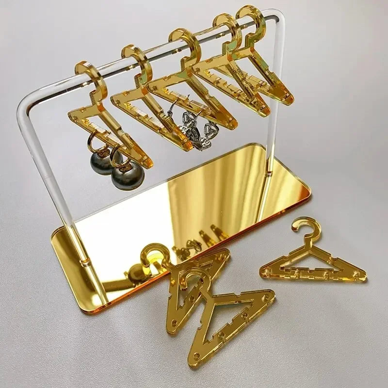 Rangement pour bijoux doré avec cintres en acrylique jaune et base effet or, parfait pour sublimer vos trésors sur une coiffeuse chic.