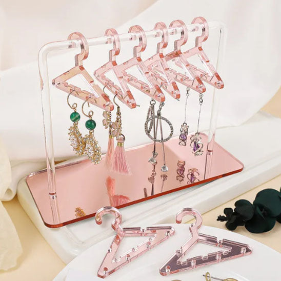 Femme suspendant facilement un collier sur un mini cintre du rangement pour bijoux.