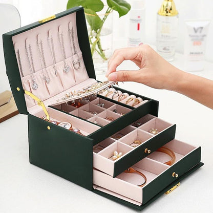 Boite à bijoux compacte avec poignée robuste, idéale à emporter en voyage ou au quotidien.