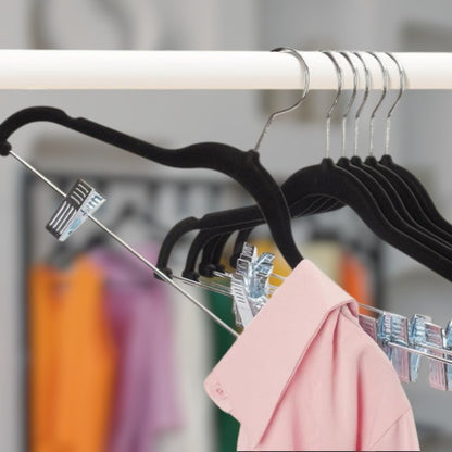 Cintres pince alignés dans un dressing moderne parfaitement organisé