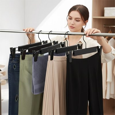 Cintre pour pantalon avec clips réglables dans un dressing organisé