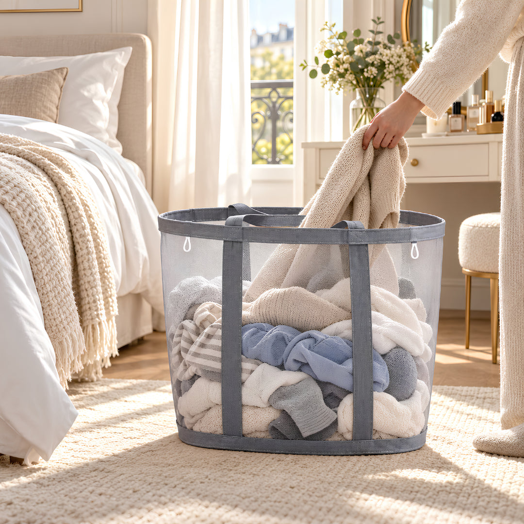 panier linge sale en maille grise Filet Pliable™ dans une chambre lumineuse avec linge du quotidien