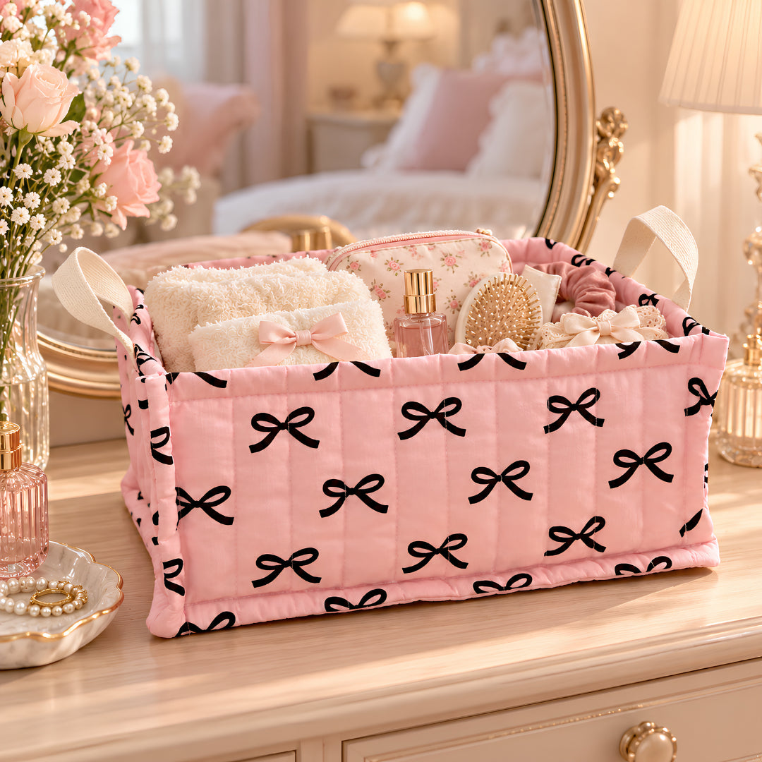 panier tissu rose à motifs de nœuds noirs posé sur une commode dans une chambre élégante pour organiser les petits accessoires