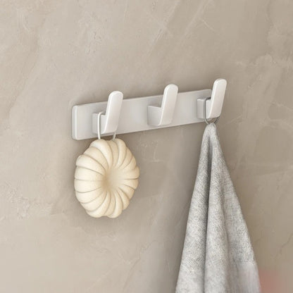 Patères murales blanches avec trois crochets pour vestes et accessoires.