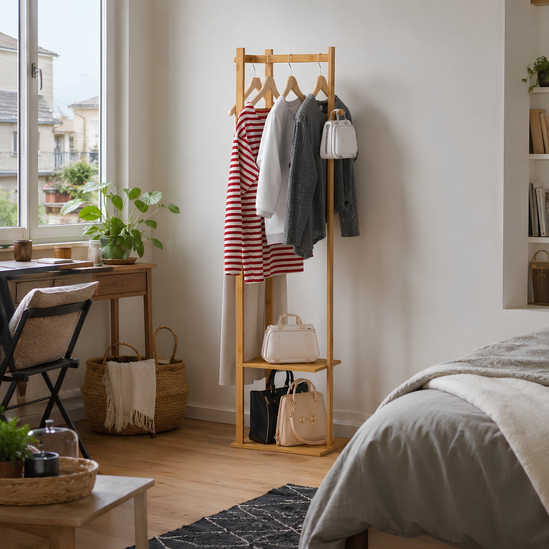 Portant vetement bois en bambou dans une chambre française lumineuse, avec vêtements, sacs et accessoires organisés dans un format compact