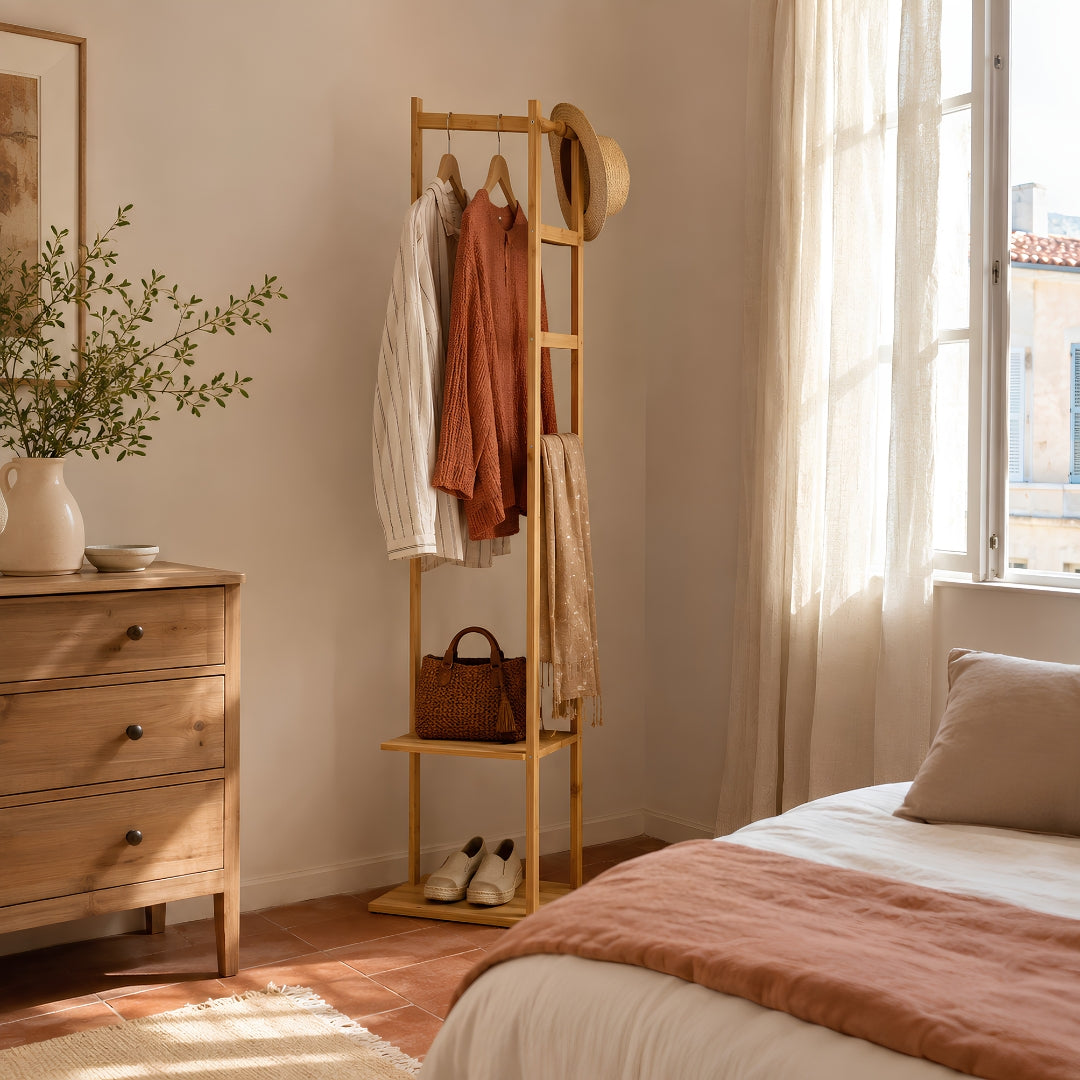 Portant vetement bois en bambou dans une chambre marseillaise lumineuse, avec vêtements, chapeau, sac et chaussures soigneusement organisés