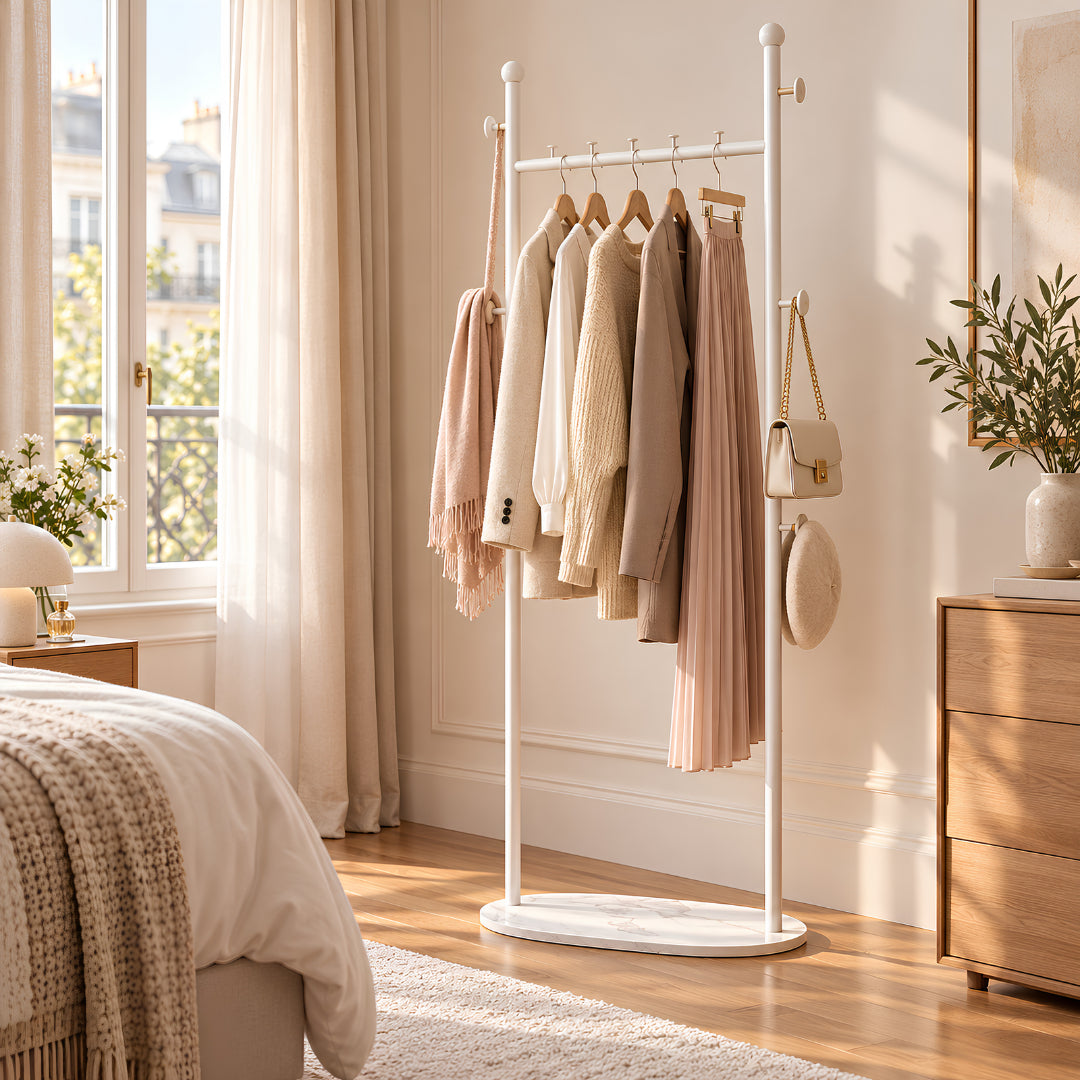 Porte vêtement blanc dans une chambre lumineuse avec vêtements, sac et accessoires organisés