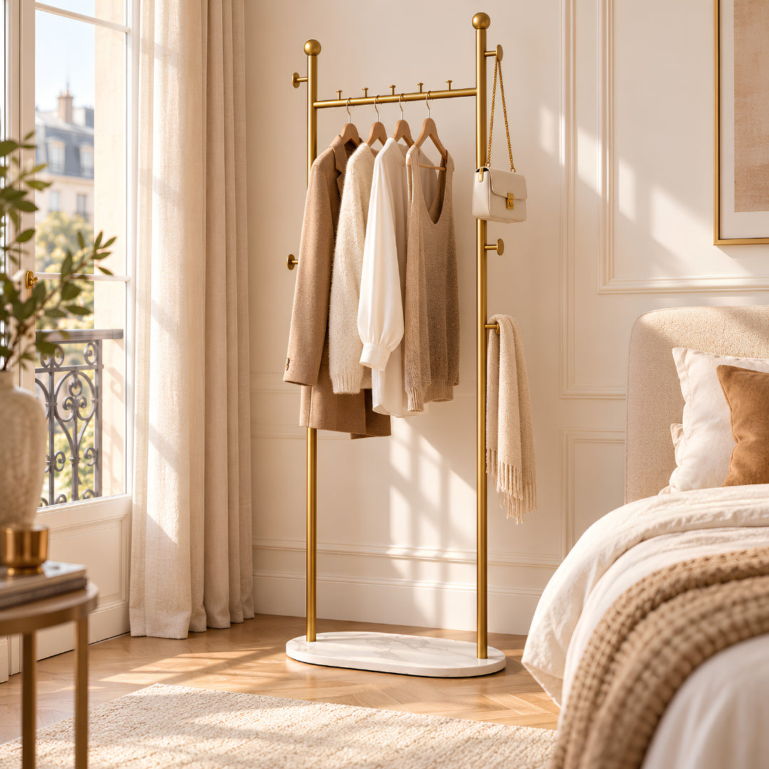 Porte vêtement doré dans une chambre élégante avec vêtements et accessoires soigneusement rangés