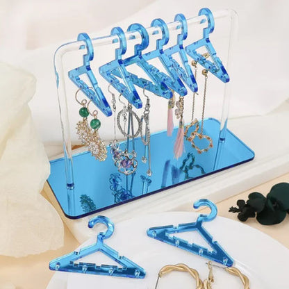 Femme souriant en retrouvant une boucle d’oreille offerte, rangée dans le rangement pour bijoux.